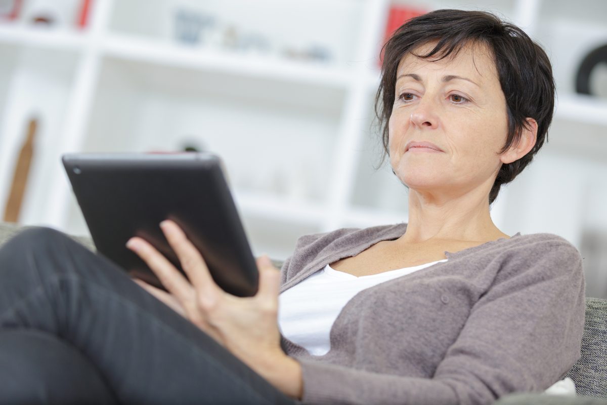 A family member at home reading a care record on a tablet